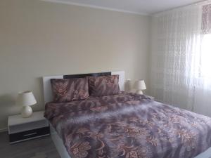 a bedroom with a large bed and two lamps at Guesthouse Dida in Sapareva Banya