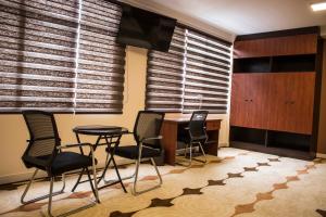 a dining room with chairs and a table and blinds at Hotel Pairumani in Cochabamba