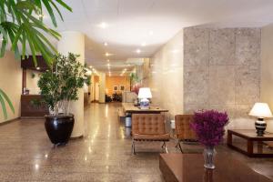 een lobby met stoelen en tafels in een gebouw bij Hotel Rojas All Suite in Sao Paulo