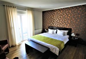 een slaapkamer met een groot bed en een groene deken bij Feriendomizil am Lindenplatz in Bullay