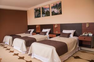 ein Zimmer mit drei Betten in einem Zimmer in der Unterkunft Hotel Pairumani in Cochabamba + 38 Fotos
