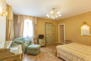 a bedroom with a bed and a chair and a table at Locanda Barbarigo in Venice