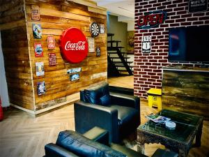 a living room with a coca cola sign on a wall at 12th Avenue in Lahore