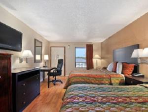 una camera d'albergo con letto e scrivania di Days Inn by Wyndham Arcadia ad Arcadia