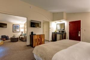 a hotel room with a bed and a living room at The Garrison Hotel & Suites Dover-Durham, Ascend Hotel Collection in Dover