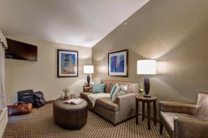 a living room with a couch and a chair at The Garrison Hotel & Suites Dover-Durham, Ascend Hotel Collection in Dover