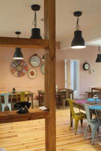 una sala da pranzo con tavoli, sedie e orologi alle pareti di GoodTime Marquês Suites a Lisbona