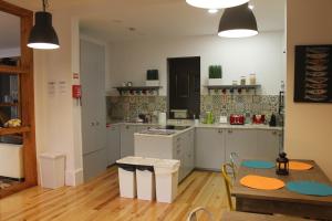 una cucina con mobili bianchi e un tavolo e una sala da pranzo di GoodTime Marquês Suites a Lisbona Altre 59 foto