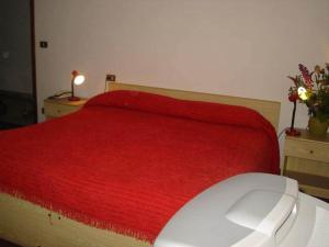 a bedroom with a red bed with a computer mouse at Hotel Cime d'Auta in Falcade
