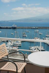 a boat sitting on top of a pier next to a bay at Azoris Faial Garden – Resort Hotel in Horta