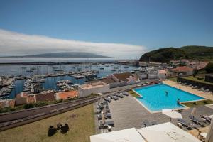 a resort with a pool and a marina with boats at Azoris Faial Garden – Resort Hotel in Horta