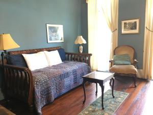 um quarto com uma cama, uma cadeira e uma mesa em Garden District Bed and Breakfast em Nova Orleans