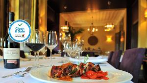 a table with a plate of food and wine glasses at Quinta da Palmeira - Country House Retreat & Spa in Cerdeira