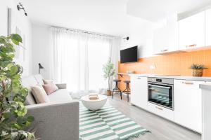 uma sala de estar com um sofá e uma cozinha em Cool Apartments by Olala Homes em Madri