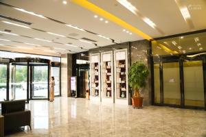 a woman standing in the lobby of a building at Lavande Hotel Zhumadian High Speed ​​Railway Station in Zhumadian