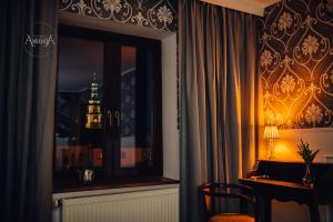 Pokój z oknem i biurkiem z lampką w obiekcie Apartament Ambasada w mieście Zamość