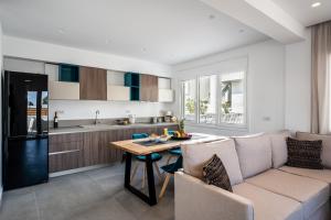 a kitchen and living room with a table and a couch at Thira Gold Suites in Fira