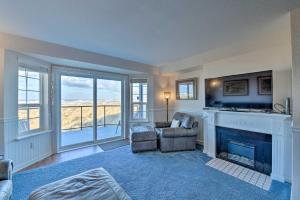 a living room with a fireplace and a chair at Eagles View Condo in Ocean Shores with 3 Balconies in Ocean Shores