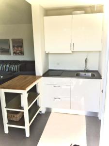 una cocina con armarios blancos y fregadero en Slettestrandvej Apartment - Slettestrandvej 130 nr. 7 - ID 627, en Slettestrand