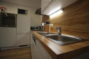 una cocina con fregadero de acero inoxidable y encimera de madera en Appartementhaus Lercher, en Flattach