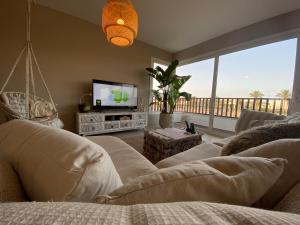 a living room with a couch and a television at Almaza bay Beach Town Chalet in Marsa Matruh
