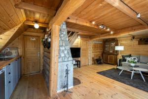 a living room with a fireplace in a log cabin at Domek Rożnów 2 in Rożnów