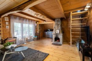 a living room with a fireplace in a log cabin at Domek Rożnów 2 in Rożnów
