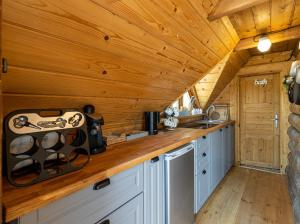a kitchen in a cabin with wooden walls and wooden counters at Domek Rożnów 2 in Rożnów +22 photos