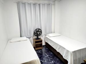 ein Zimmer mit zwei Betten und einem Fenster in der Unterkunft Edifício Louise – Apto 301 in Chapecó