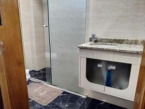 ein Badezimmer mit Glasdusche und Waschbecken in der Unterkunft Edifício Louise – Apto 301 in Chapecó + 2 Fotos