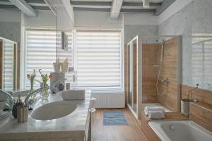 a bathroom with a tub and a sink and a shower at Het Gecroonde Swaert B&B in Middelburg +32 photos