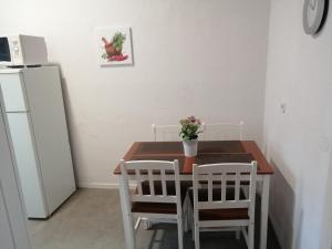 Wohnung in Köln 2B في كولونيا: مطبخ مع طاولة وكراسي وثلاجة
