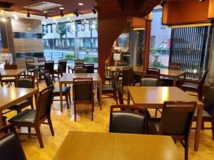 a restaurant with wooden tables and chairs and windows at Hotel Ascent Hamamatsu / Vacation STAY 79775 in Hamamatsu