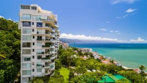 a tall building with the ocean in the background at AVALON - 1002 Amapas Bay Bliss with Private Pool in Puerto Vallarta