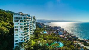a tall building next to the water with a resort at AVALON - 1002 Amapas Bay Bliss with Private Pool in Puerto Vallarta