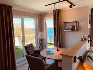 a living room with a table and a large window at Penthouse-Suite am Plöner See in Ascheberg