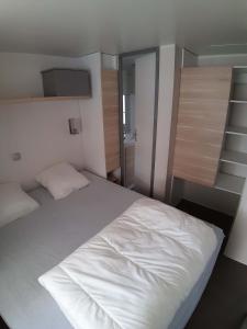 1 cama blanca grande en un dormitorio pequeño en Ushuaïa Villages Camping Figurotta, en Bizanet