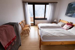 sypialnia z 2 łóżkami i oknem w obiekcie Panorama at Haus Waldheim Nr. 11 w mieście Grächen