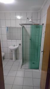 uma casa de banho com uma cabina de duche em vidro e um lavatório. em Hotel Biz em São Paulo