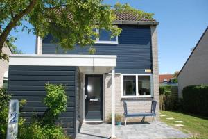a blue house with a bench in front of it at Vakantiehuis Grevelingen 12 aan Grevelingenmeer. nabij Port Greve in Brouwershaven