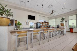 a lobby with a bar with stools and a tv at Peninsula Island Resort & Spa - Beachfront Property at South Padre Island in South Padre Island