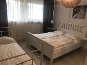 een slaapkamer met 2 bedden en een raam bij Baynunah Suites Aparthotel in München