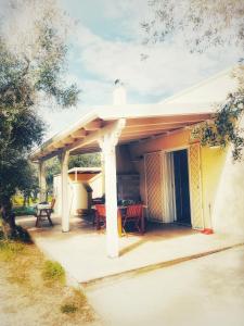 Casa con porche con mesa y sillas en Villa Mios, en Muro Leccese