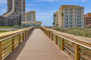 a wooden boardwalk over the beach with buildings at Peninsula Island Resort & Spa - Beachfront Property at South Padre Island in South Padre Island