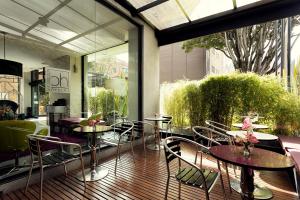 Hotel bh Parque 93 في بوغوتا: مطعم بطاولات وكراسي على فناء