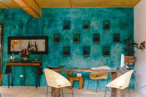 Habitación con pared azul, mesa y sillas. en La Puerta Azul Beachfront - Adults Only en Holbox Island