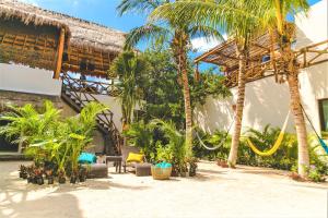 un complejo con palmeras y un edificio en La Puerta Azul Beachfront - Adults Only, en Isla Holbox