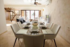 a dining room with a table and white chairs at El Faro 304 Coral Penthouse in Playa del Carmen