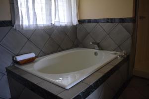 a white bath tub in a bathroom with a window at The Kauai Inn in Lihue