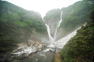 a waterfall on the side of a mountain at Midagahara Hotel in Tateyama